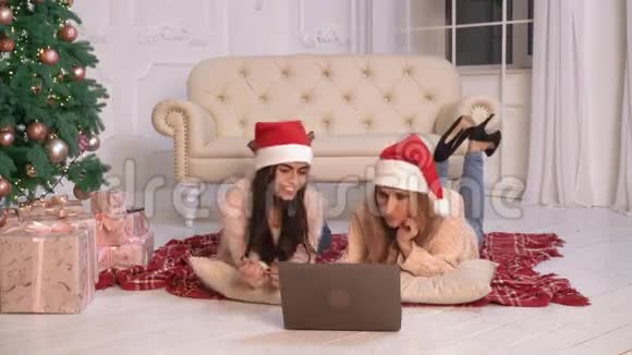 两个快乐的女士与个人电脑在平淡的圣诞节视频的预览图