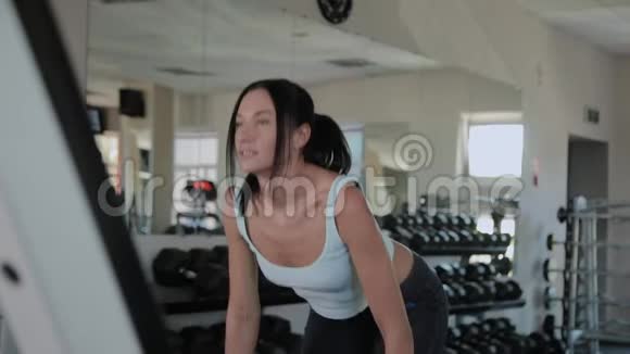 漂亮的运动女人在健身房做举重视频的预览图