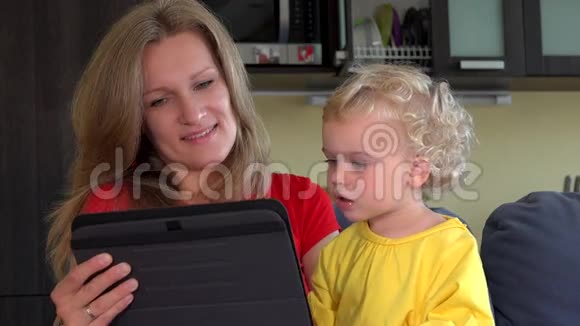 妈妈和小女儿开始和爸爸在平板电脑上视频对话视频的预览图
