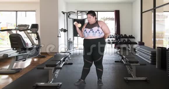 超重的女人用哑铃做运动视频的预览图