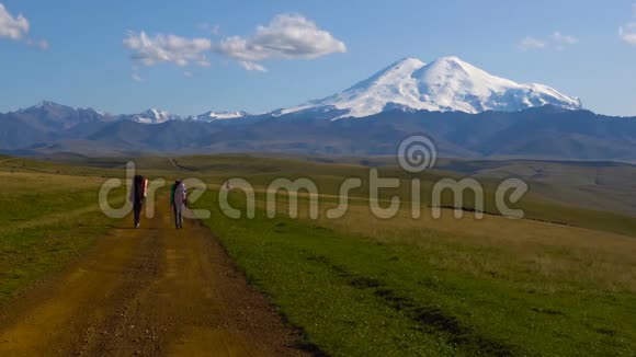 两个人正在高加索山脉的公路边徒步旅行朋友们将登上Elbrus4KUHD视频的预览图