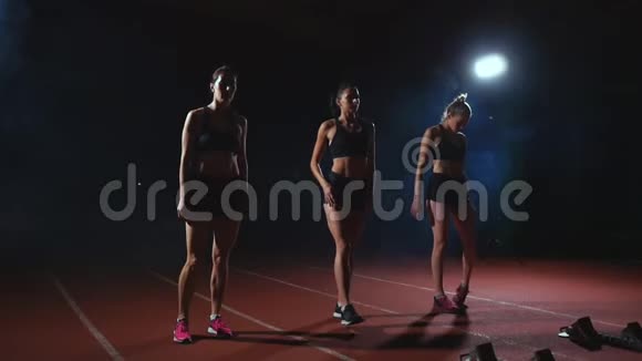 3个穿着黑色衣服的女孩在比赛开始前垫着灯光开始比赛视频的预览图