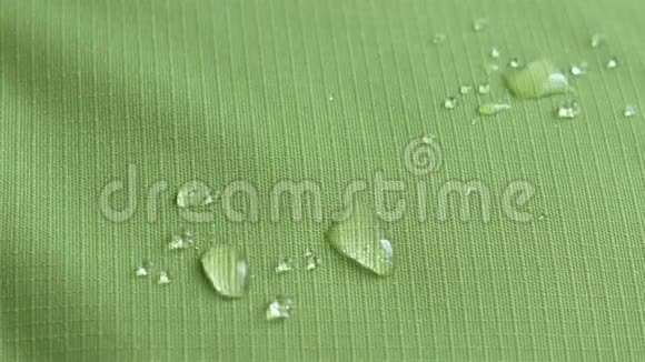 水滴落在绿色防水面料上撕拉特写视频的预览图