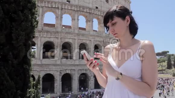 年轻的白种人女游客用手机在欧洲古城的美丽景色上发短信视频的预览图