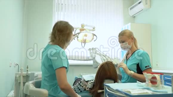 牙医用镜子检查年轻女人的牙齿视频的预览图