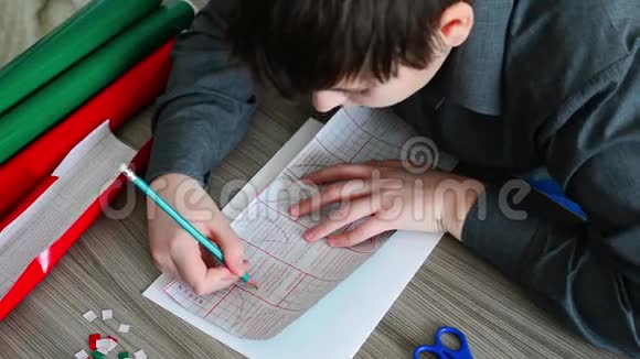青少年男孩用彩色自动黏贴纸画圣诞卡的细节视频的预览图