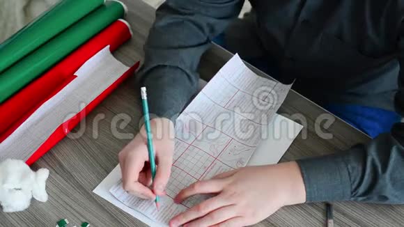 青少年男孩用彩色自动黏贴纸画圣诞卡的细节视频的预览图