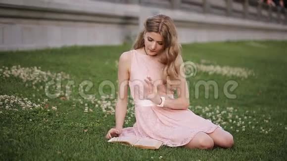 公园草坪上的女孩读着一本迷人的书笑了起来视频的预览图