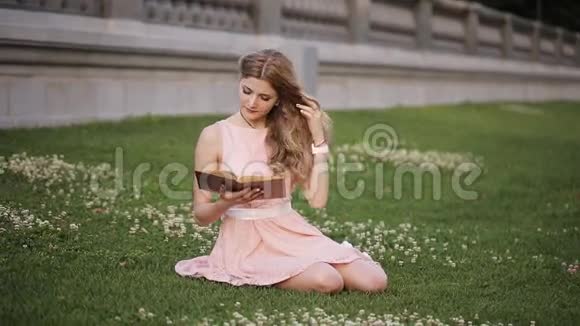 公园里一个非常漂亮的女孩拿着一本书视频的预览图