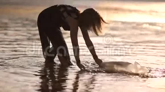 女孩在河里洗衣服透明的黑色帕雷奥视频的预览图