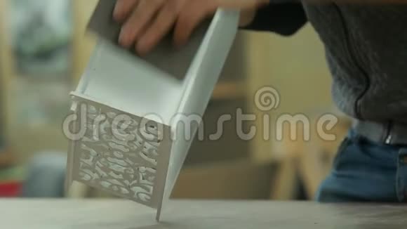 特写男手的专业工人用砂纸打磨礼品产品视频的预览图