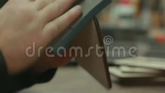特写男手的专业工人用砂纸打磨礼品产品视频的预览图