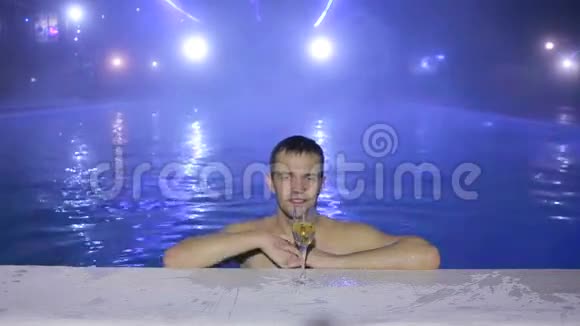 快乐的人晚上在游泳池里游泳用眼镜喝酒热源视频的预览图