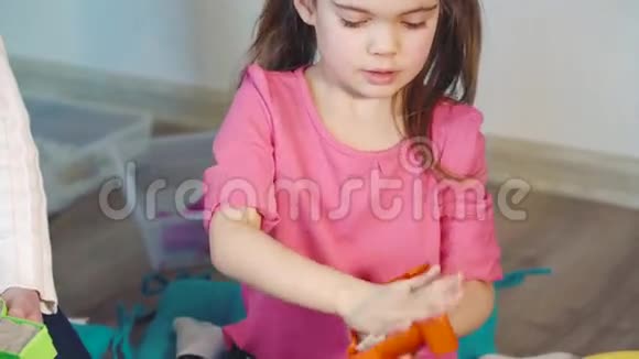 一个可爱的小女孩在家玩动能沙视频的预览图