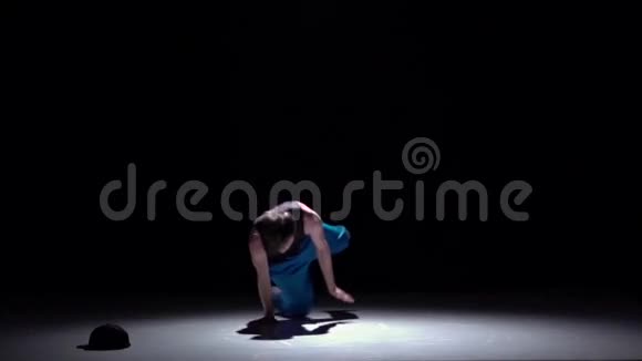 穿着蓝色裤子跳舞的舞者在他的手上跳舞黑色阴影慢动作视频的预览图
