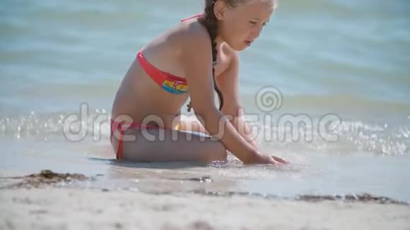 在沙滩上玩沙子的女孩视频的预览图
