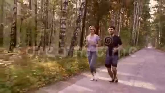 年轻的一对夫妇在森林里尽情地奔跑视频的预览图