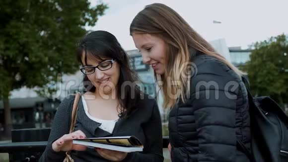 两个女孩在伦敦市中心读旅游指南视频的预览图