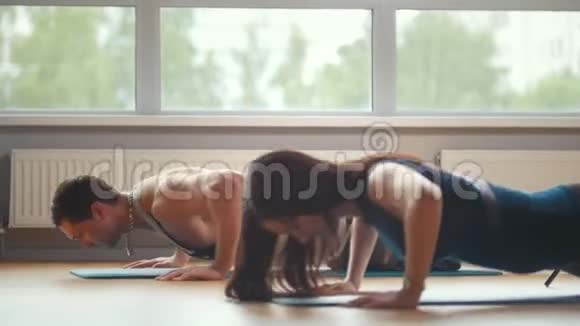 性伴侣女孩和男人一起在健身房做俯卧撑家庭健身视频的预览图