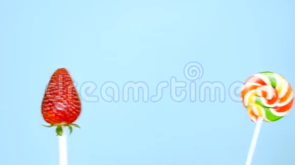 健康和不健康食品的概念在明亮的蓝色背景上用草莓做糖果视频的预览图