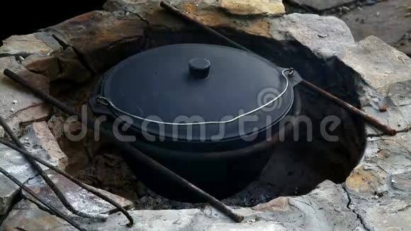 乌兹别克民族菜皮拉夫在一个大型铸铁大锅上着火混合现成皮拉视频的预览图