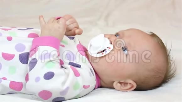 新生儿躺在床单上吸奶奶嘴视频的预览图