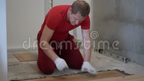 修理和装饰tiler把瓷砖放在公寓的地板上视频的预览图