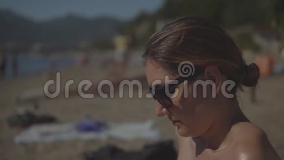 戴太阳镜的年轻女子放松和日光浴视频的预览图