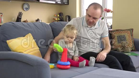 可爱的女孩和慈爱的父亲玩五颜六色的金字塔戒指男子推荐女儿视频的预览图