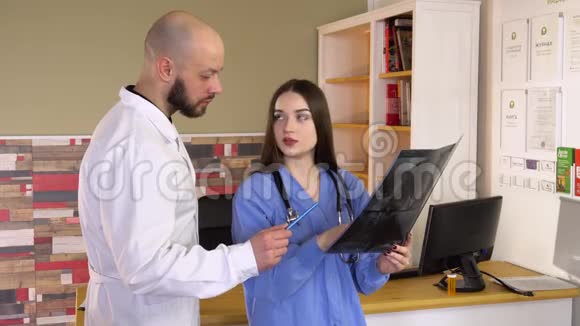 穿白色实验室外套的医生告诉护士他的病人在临床上的结果视频的预览图