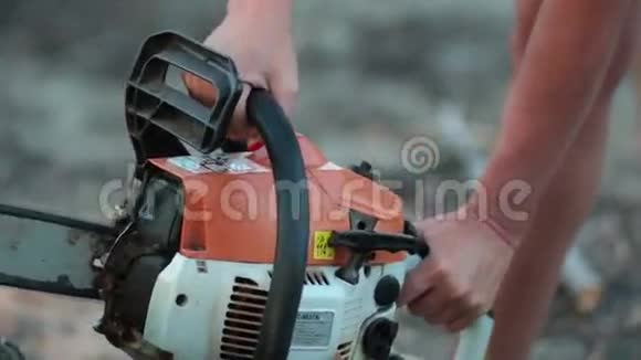 用电锯锯干木头的女性手视频的预览图