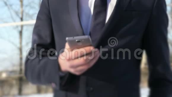 冬天街上拿着银色智能手机的男人视频的预览图