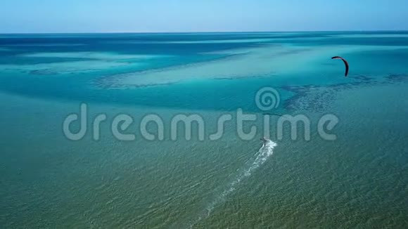 鸟瞰年轻人在热带蓝色海洋中的风筝冲浪视频的预览图