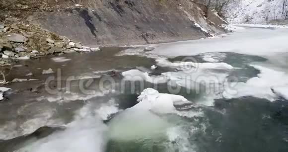 空中景色冰融化河水流动冬季喀尔巴阡山脉的一条山河视频的预览图