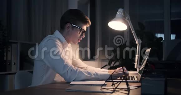 商人深夜在办公室笔记本电脑上打字视频的预览图