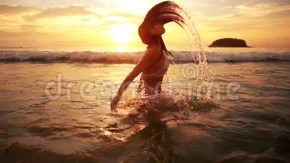 夕阳中的女人从水中溅起视频的预览图