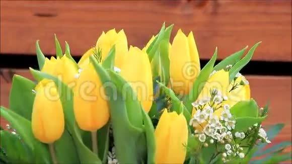 黄色的郁金香花束与白色的小花朵旋转视频的预览图