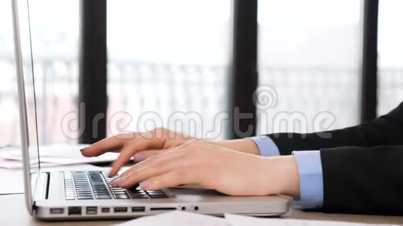 女商人用手在笔记本电脑键盘上打字视频的预览图