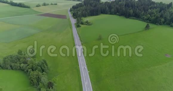 高速公路穿越绿色草地和森林的空中视频视频的预览图