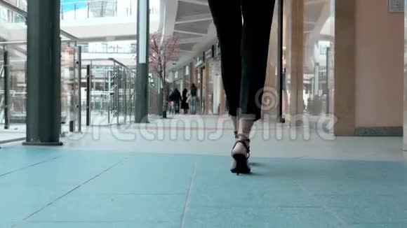 把站在办公室附近的工人的女腿合上那女人穿高跟鞋办公楼或购物视频的预览图