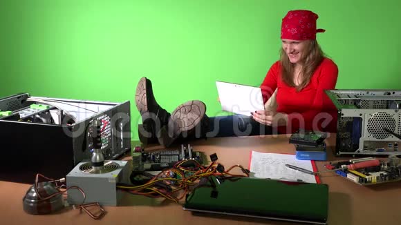 粗心的工程师女士腿在桌子上玩平板电脑视频的预览图
