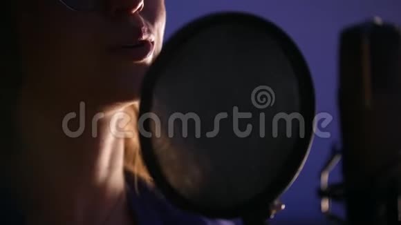 一位年轻女子在录音室录制一首歌视频的预览图