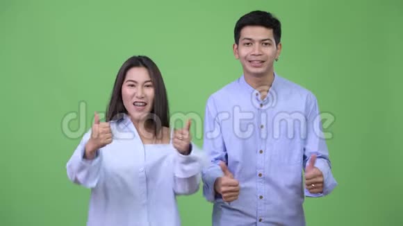 年轻快乐的亚洲商务情侣一起竖起大拇指视频的预览图
