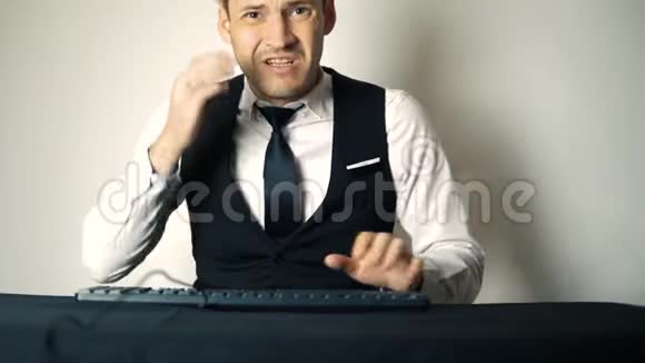 年轻的办公室商人在做台式电脑微笑的商人在现代办公室的电脑上敲键盘快乐视频的预览图