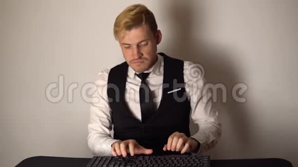 年轻的办公室商人在做台式电脑微笑的商人在现代办公室的电脑上敲键盘快乐视频的预览图