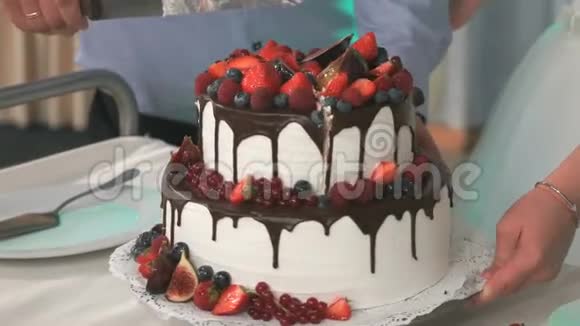 新婚夫妇切着美味的甜蜜婚礼蛋糕视频的预览图