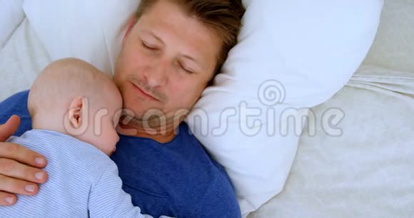 爸爸和小男孩睡在卧室4k视频的预览图