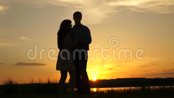 爱的男人和女人在湖底明亮的阳光下跳舞一对年轻夫妇在海滩日落时跳舞视频的预览图