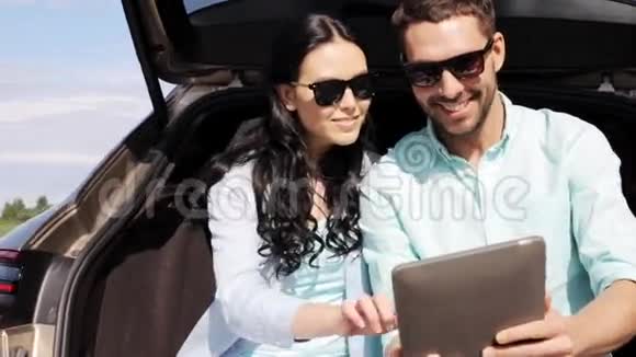 在掀背车后备箱3上有平板电脑的幸福夫妇视频的预览图