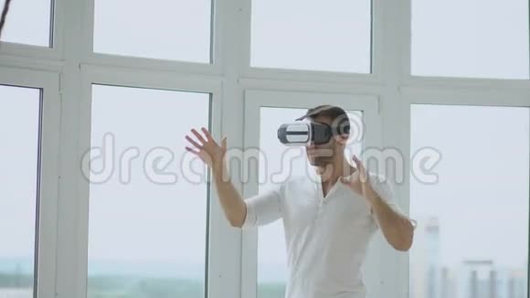 年轻人使用手势控制虚拟现实耳机的虚拟现实体验视频的预览图